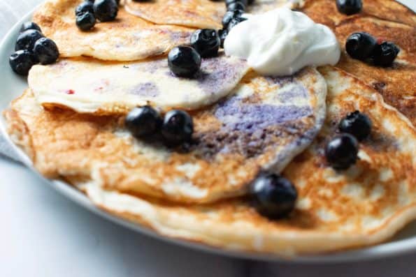 coconut pancakes on a white plate with blueberries