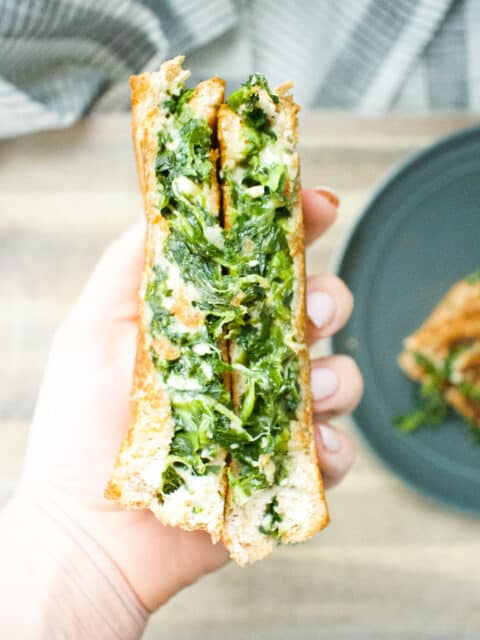 spinach filled grilled cheese being held