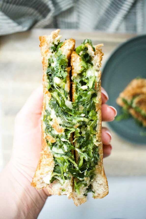spinach filled grilled cheese being held