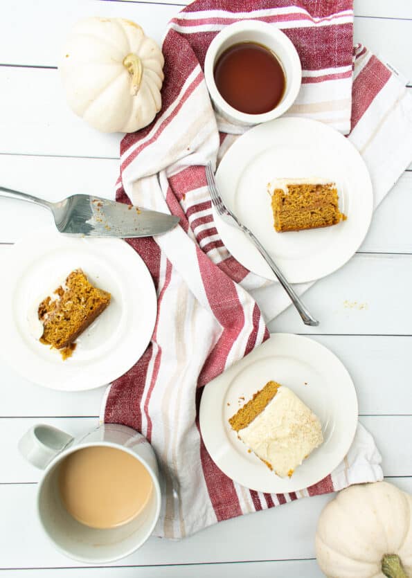 three white plates with slices of cake surrounded with syrup and coffee