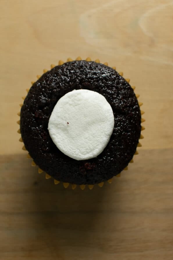 chocolate cupcake with a marshmallow core on a wood table 