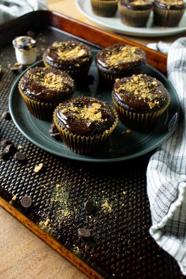 chocolate cupcakes with chocolate frosting on a plate with white towel