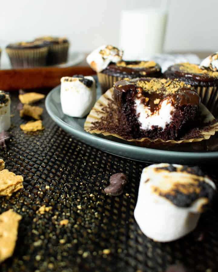 chocolate cupcake with bite showing marshmallow center on a plate