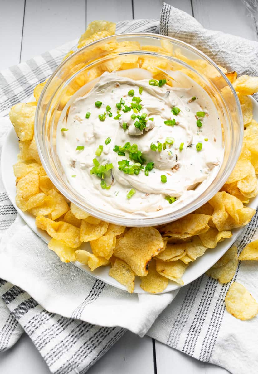 dip in a clear bowl surrounded by potato chips